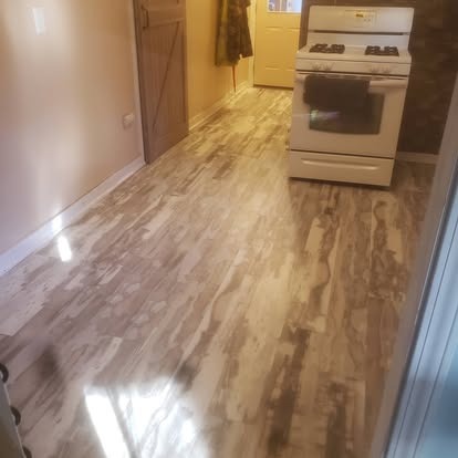 Kitchen with wood-look vinyl flooring, white stove, and yellow refrigerator