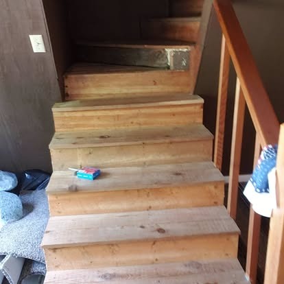Wooden staircase with light wood steps leading upward in an indoor residential space