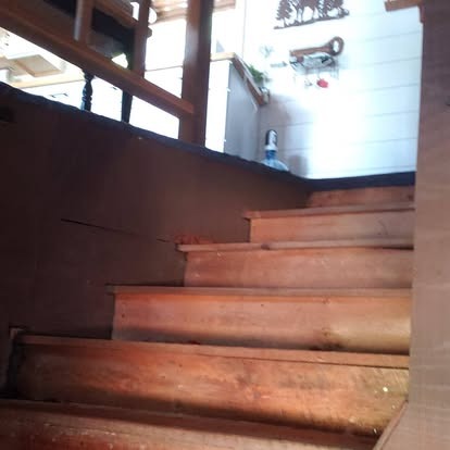 Wooden staircase leading upward with natural light from above