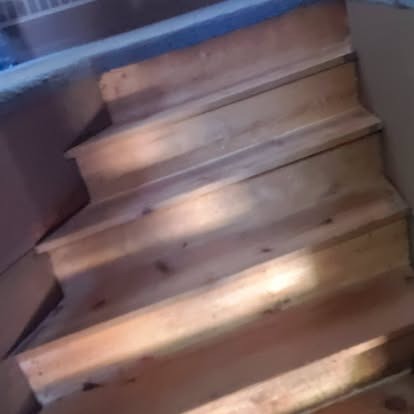 Wooden staircase with metal railings lit by warm lighting
