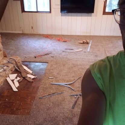 Interior renovation in progress with exposed flooring, cables, and construction materials scattered throughout room