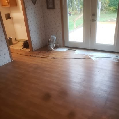 Empty room with wood flooring, glass doors, and patterned wallpaper
