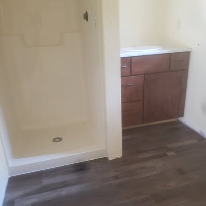 Bathroom interior with walk-in shower enclosure and wooden vanity cabinet