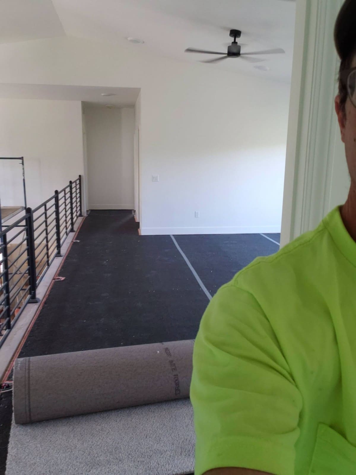 Professional flooring installation in progress with dark tile and carpet materials in modern office space