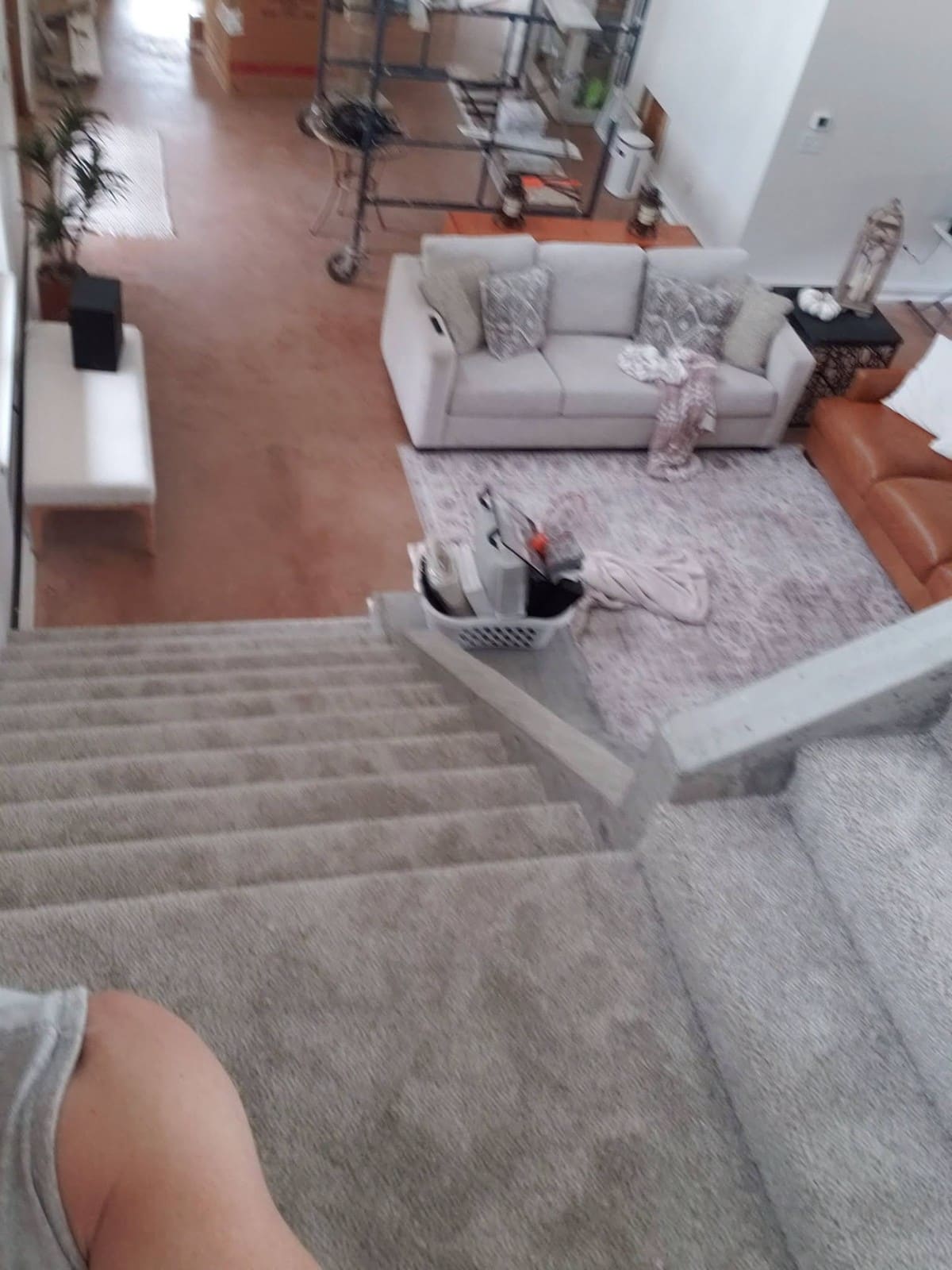 Overhead view of modern living room with white sofa, terracotta flooring, and gray area rug